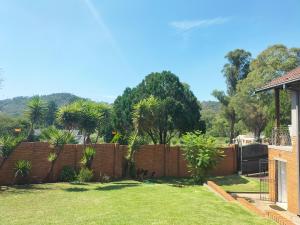 a fence in a yard with trees in the background at The protea nest in Johannesburg