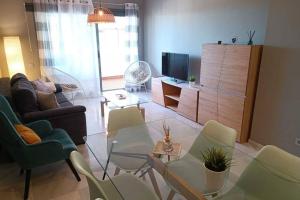 a living room with a glass table and chairs at Apartamento con vistas al mar in Fuengirola