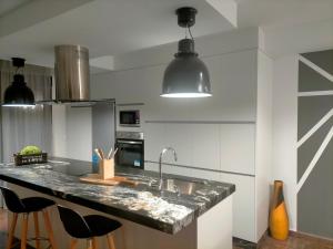 a kitchen with a sink and a counter with stools at Piso turistico el Sol VUT-983 in Astorga