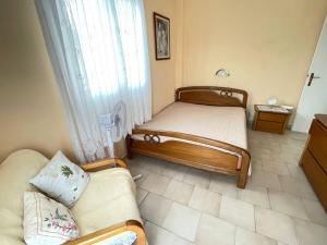 a small bedroom with two beds and a couch at Marithea apartment in Pefkochori