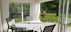 a table and chairs in a room with a window at Holiday House Vela Vrta in Sveti Ivan Dobrinjski