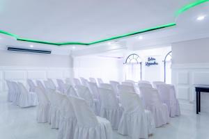 una fila de sillas blancas en una habitación blanca en Hotel Villa Antigua en San Salvador