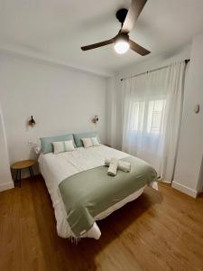 a bedroom with a large bed with a ceiling fan at Piso Picasso, Modern Apartment in the Heart of Malaga City in Málaga