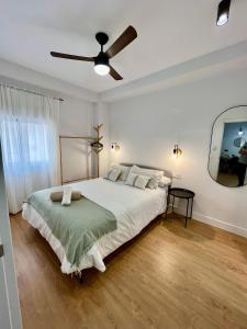a bedroom with a large bed with a ceiling fan at Piso Picasso, Modern Apartment in the Heart of Malaga City in Málaga