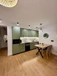 una cucina con mobili verdi e un tavolo di legno di Piso Picasso, Modern Apartment in the Heart of Malaga City a Málaga