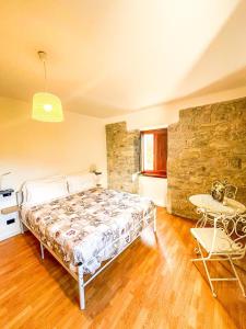 - une chambre avec un lit, une table et un mur en pierre dans l'établissement Casale Cipriani, 