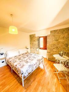a bedroom with a bed and a table and a stone wall at Casale Cipriani in Casalciprano +66 photos