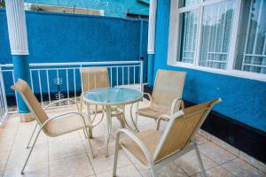grupa krzeseł i stół na ganku w obiekcie PEACE Homes w mieście Kigali