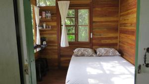 um quarto com uma cama num quarto com uma janela em Cabanas sítio Ancestral em Morretes