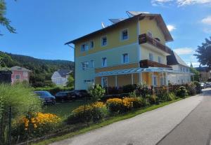 a yellow and white building on the side of a road at Sonnblick am Wörthersee in Pörtschach am Wörthersee
