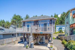 a house with a porch and a balcony at Coastal Dream in Lincoln City