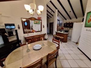 a dining room with a table and a kitchen at HERMOSA Y COMODA CASA FAMILIAR EN Baños in Baños