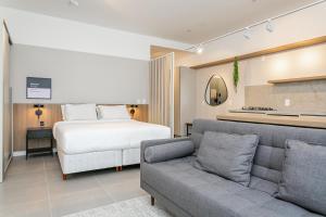 un salon avec un lit et un canapé dans l'établissement Studios Tower by Viva - Prédio com piscina e estacionamento no centro de Floripa, à Florianópolis