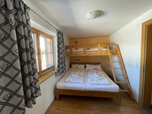 a small room with a bunk bed and a ladder at Gästehaus Katharina in Hochfilzen