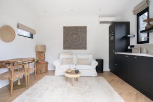 a living room with a white couch and a table at Bed and Breakfast Bij ons in het bos in Bergen op Zoom