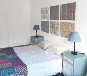 a bedroom with a bed with two tables and two lamps at O Sardinhas in Matosinhos