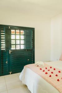 um quarto com uma cama com rosas vermelhas em Villa Nova Holanda em Mulungu