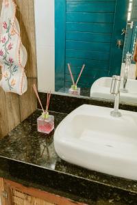 a bathroom counter with a white sink and a mirror at Villa Nova Holanda in Guaramiranga +62 photos