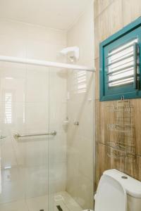 a bathroom with a toilet and a glass shower at Villa Nova Holanda in Mulungu