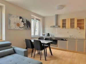 eine Küche und ein Wohnzimmer mit einem Tisch und Stühlen in der Unterkunft City Apartment Sankt Pölten in Sankt Pölten