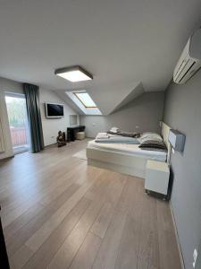 una grande camera da letto con un letto e un pavimento in legno di Great spacious villa near Prague 