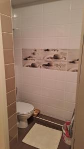 łazienka z toaletą i ścianą wyłożoną kafelkami w obiekcie Аэропорт Апартаменты Комфорт w Kiszyniowie