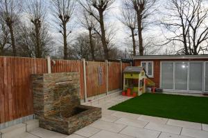 um pequeno quintal com um parque infantil e uma casa de jogos em Cozy, modern, spacious 4 bedroom house in london em Romford