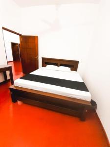 Cama en habitación con suelo de color naranja en VILLA AAA WELIGAMA, en Weligama