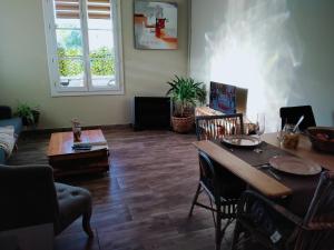 een woonkamer met een houten tafel en stoelen bij Gure Doya in Billère