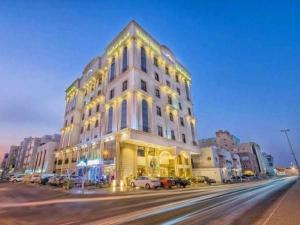 a large white building on a city street at night at SANSA HOTEL in Jeddah