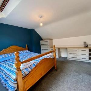una camera con letto in legno e parete blu di The Mustard Seed a Kilkeel