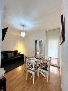 uma sala de estar com uma mesa e cadeiras e um sofá em Apartment carrer d'Olesa em Barcelona