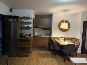 a kitchen with a table and a black refrigerator at Nassfeld Sonnleitn Apartment 1 in Sonnenalpe Nassfeld