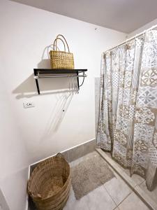 a bathroom with a basket and a shower curtain at Affordable Condo beside Ayala Mall Bacolod! in Bacolod