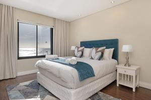 a bedroom with a large bed with a view of the ocean at Eden on the Bay 167 by HostAgents in Bloubergstrand