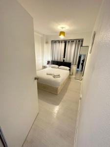 3 Bedroom King Cross station City centre London في لندن: غرفة نوم بيضاء بها سرير ونافذة