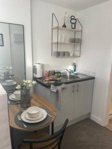 una pequeña cocina con mesa y fregadero en (NEW) Poppy's place - 10 minute drive from York en Skelton