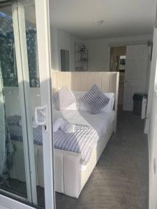 een slaapkamer met een wit bed met kussens erop bij (NEW) Poppy's place - 10 minute drive from York in Skelton
