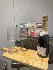 Una botella de champán y dos copas en una mesa. en (NEW) Poppy's place - 10 minute drive from York en Skelton
