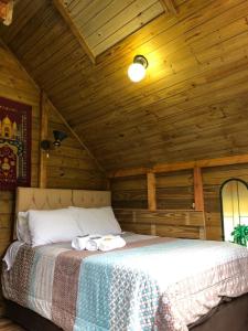 - une chambre avec un lit et 2 serviettes dans l'établissement cabanas luar, à São Francisco de Paula