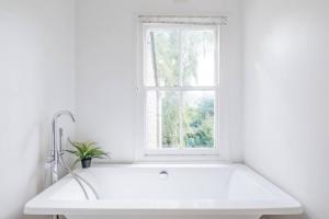 a white kitchen with a sink and a window at Lovely 2 bedroom house in Cambridge (sleeps 4) in Cambridge