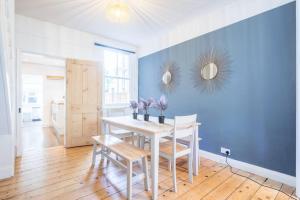 a dining room with a table and a blue wall at Lovely 2 bedroom house in Cambridge (sleeps 4) in Cambridge