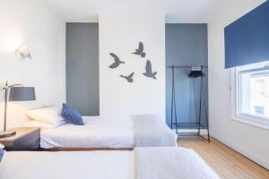 two beds in a room with birds on the wall at Lovely 2 bedroom house in Cambridge (sleeps 4) in Cambridge