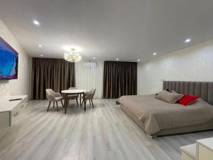 a bedroom with a bed and a table with chairs at Samarkand Central Apartments in Samarkand