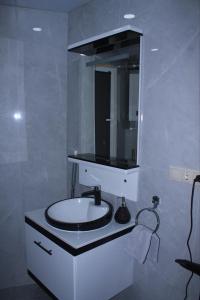 a white bathroom with a sink and a mirror at Samarkand Central Apartments in Samarkand