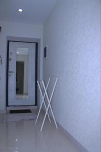 a white room with a mirror and two white chairs at Samarkand Central Apartments in Samarkand