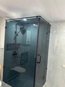 La salle de bains est pourvue d'une douche avec une porte en verre. dans l'établissement Samarkand Central Apartments, à Samarcande