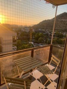 a table and two chairs on a balcony with a view at Departamento Clásico Remodelado in Santiago