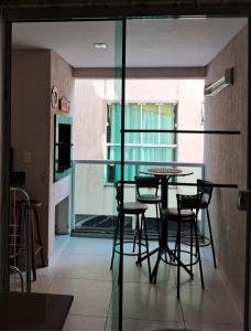 ein Esszimmer mit einem Tisch und Stühlen auf dem Balkon in der Unterkunft Residencial Atalanta in Bombinhas
