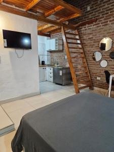 a room with a kitchen and a tv on a wall at Acogedor loft estilo industrial in Posadas